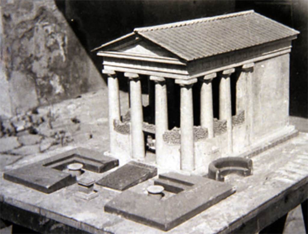 Tempio dionisiaco in località Sant’Abbondio di Pompei. Old undated photograph of reconstruction model of temple.
The walls and columns were covered in heavy coats of stucco.
The pronaos was enclosed by screen with attached benches.
It was damaged in the earthquake of 62AD and repaired by the time of the AD79 eruption.
According to Cooley, this is an indication of how deeply culture and society in Pompeii were influenced by Hellenistic traditions during the second century BC
Pompeii had continued to renovate the temple after the Rome Senate decree of 186BC, which banned the worship of Dionysus.
There is no evidence that the cult at Pompeii was interrupted.
The temple was still in use in 79AD.
See Cooley, A. and M.G.L., 2004. Pompeii: A Sourcebook. London: Routledge, p. 11.
See Cooley, A. and M.G.L., 2014. Pompeii and Herculaneum: A Sourcebook. London: Routledge, p. 15.