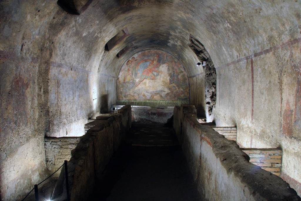 Santa Maria Capua Vetere, Mithraeum. 2011.
On the long sides of the Mithraeum, which is accessed through a small door, the benches reserved for believers can be seen: they are made of masonry with the top inclined towards the wall, and are fitted with small basins and wells. The channel served to collect the blood of sacrificed animals and drain it into a well. Fixed to the south wall there was a marble relief, edged in red, representing Cupid and Psyche. See http://www.campaniartecard.it/site.cfm?id=47#image-1
