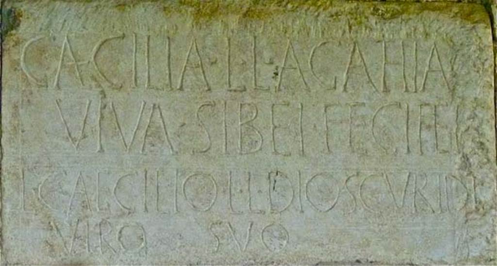 FPND Pompeii. May 2011. Plaque on front of tomb. Photo courtesy of Michael Binns.
The inscription reads
CAECILIA L. L. AGATHIA
VIVA SIBEI FECIT ET
L. CAECILIO L. L. DIOSCVRIDI
VIRO SVO.
D’Ambrosio and De Caro expand this to:
Caecilia L(uci) l(iberta) Agathia
viva sibei fecit et
L(ucio) Caecilio L(uci) l(iberto) Dioscuridi
viro suo.
They name the tomb after Caecilia Agathia, the freedwoman of a Lucius Caecilius, and her husband Lucius Caecilius Dioscurides, a freedman of the same patron.
See D’Ambrosio A. and De Caro S., 1988. Römische Gräberstraßen. München: C.H.Beck. p. 206.