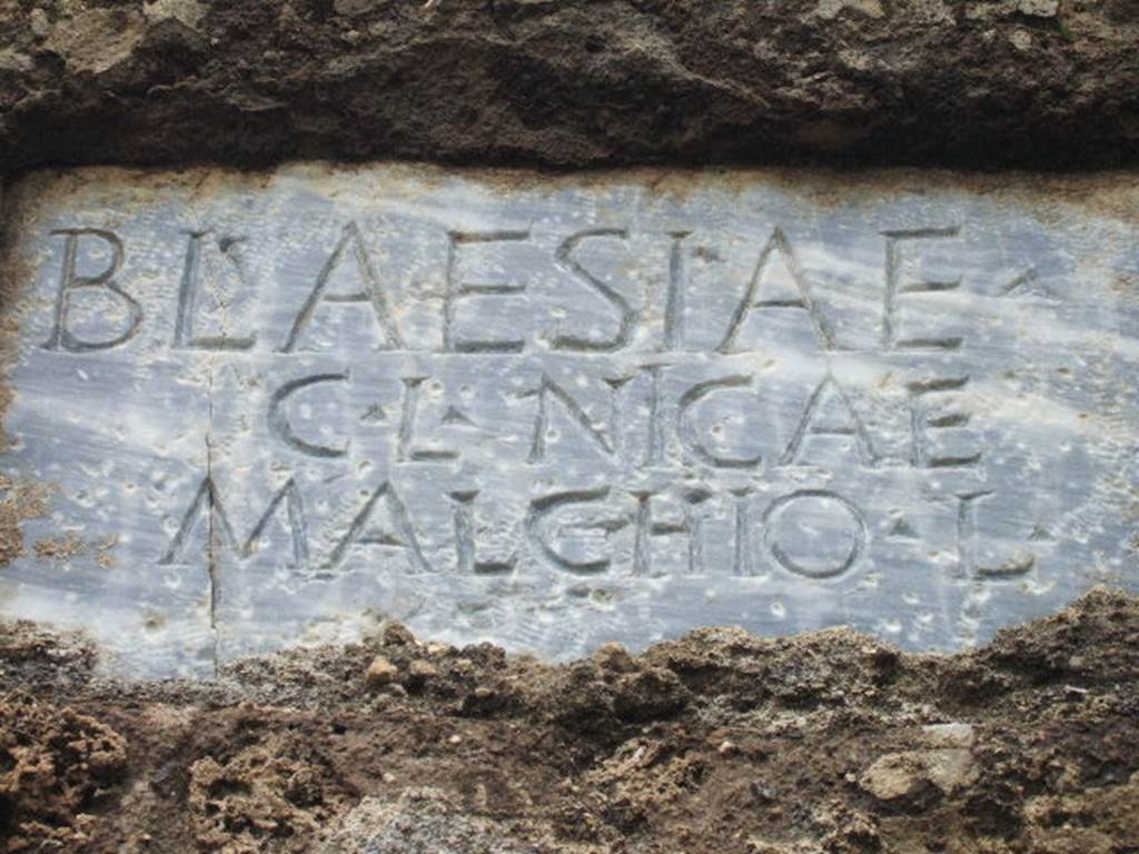 FPNH Pompeii. December 2005. Light blue marble plaque in centre of south side, with inscription.
According to D’Ambrosio and De Caro, this read
BLAESIAE C. L. NICAE MALCHIO L.
They expand this to
Blaesiae
C(ai) l(ibertae, Nicae
Malchio l(ibertus)
See D’Ambrosio A. and De Caro S., 1988. Römische Gräberstraßen. München: C.H.Beck. p. 212.