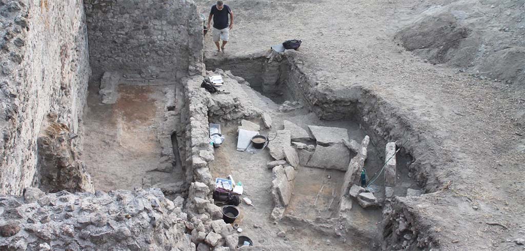 HG31A Pompeii. Tomb of a Samnite Woman. 2015. HGE30 left and tomb right.
The Samnite tomb was found in an area containing tombs from the Roman period, lavish villas and craftsmen�s shops.
It was uncovered when the wall of one of the shops was examined more closely; it was just on the other side of the partition.
No trace of the tomb cover was found.
Photograph � L.CAVASSA/CNRS-AMU .

