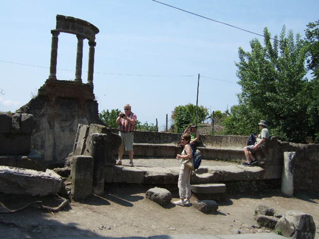 HGW04 Pompeii. May 2006. Looking west towards the schola tomb of Mamia.
According to PAH, 6 January 1785, the seat with the inscription to the priestess Mammia, which was taken 2nd August 1763 and sent to the Royal Museum at Portici was put back in its original site.
1785 6 Gennaio - Si rimette nel suo antico sito il sedile di piperno coll’iscrizione della Sacerdotessa Mammia, che ne fu tolto a' 2 agosto 1763, e mandato al R. Museo di Portici.
See Fiorelli, Pompeianarum antiquitatum historia, Vol. 1 1748 to 1818, (p. 167)