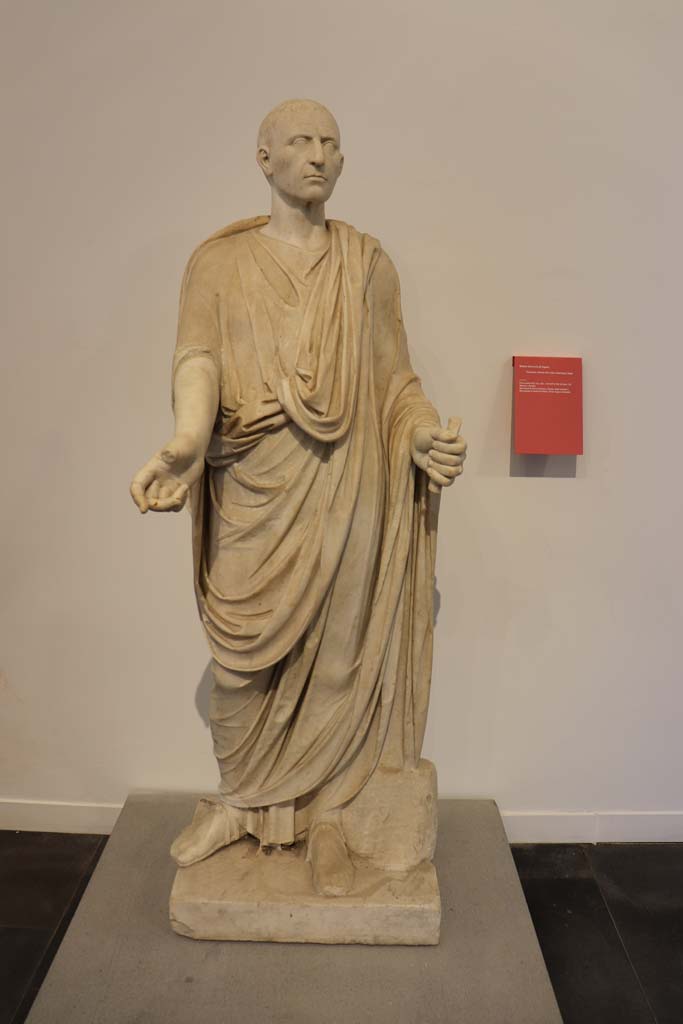 HGW04a Pompeii. February 2021.
Marble funerary statue of a man wearing a toga, from the Tombs at the Herculaneum Gate, Tomb of gens Istacidia.
Photographed on display in Antiquarium at VIII.1.4. Photo courtesy of Fabien Bièvre-Perrin (CC BY-NC-SA).