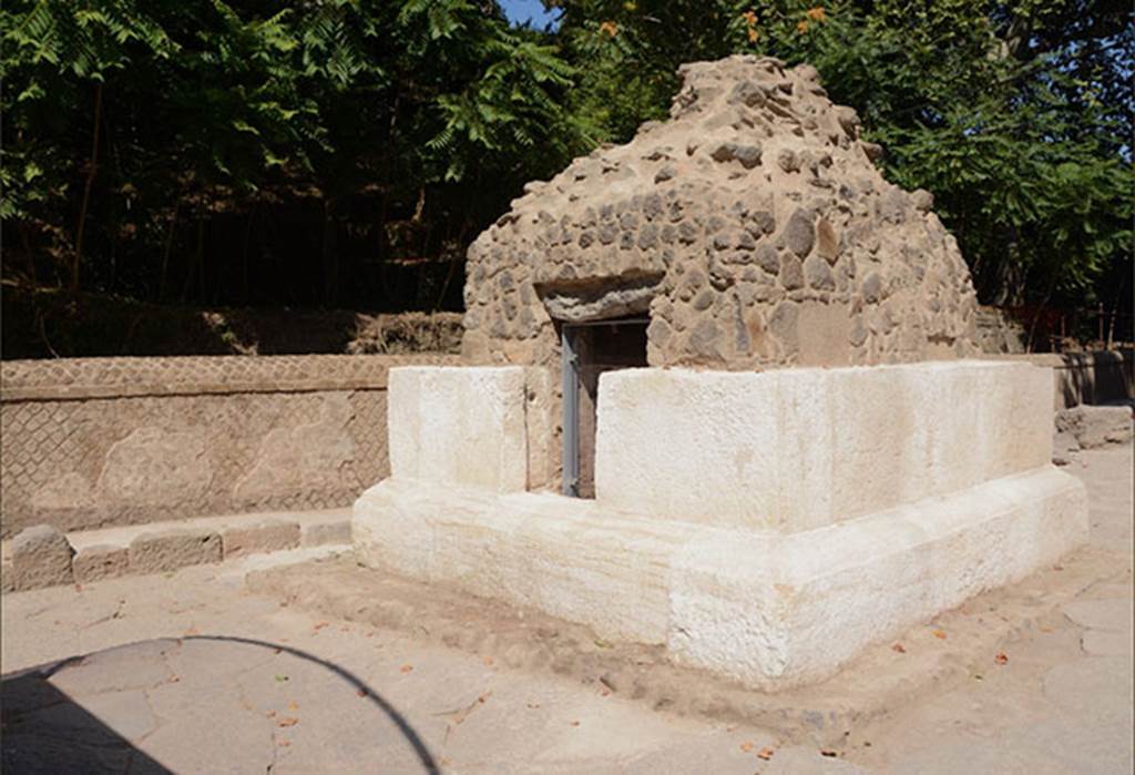 SG4 Pompeii. 2018. Side facing south away from the Stabian Gate.
The tomb, which is rectangular in shape, is formed of two rows of white limestone parallelepiped blocks; the tomb was probably crowned with an altar shaped element.
On three sides the plastered interior has rectangular niches, while the fourth includes the access to the chamber. At the time of the restoration work inside the burial chamber - which was in a poor state of conservation - it was revealed that only four of the nine clay urns fixed into the two raised areas along the sides of the chamber had previously been emptied, probably during the nineteenth century explorations, which brought about the destruction of the limestone coating of the upper part of the tomb and the removal of the glass urns in the niches.
Of the 5 urns which had not been previously emptied, two revealed the ashes of the deceased, while another two contained the remains of the ustrinum (funeral pyre), such as glass unguentaria deformed by the heat, and in one case a coin placed as a Charon’s obol (fee/bribe for ferrying). Some urns retain their lids in the closed position but inverted.
A clay conduit was discovered on the cocciopesto floor, for the libations in honour of the deceased which took place during the various festivities; the conduit was closed by a marble element.
See http://pompeiisites.org/en/comunicati/the-tombs-of-the-necropolis-of-porta-stabia/