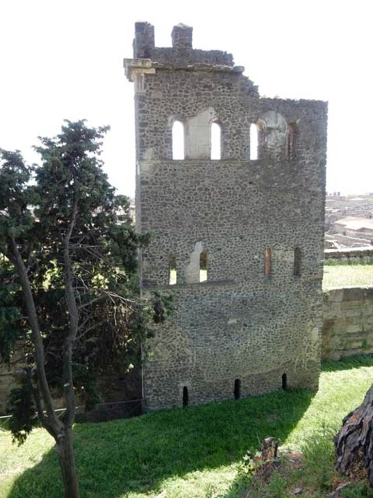 Tower X, Pompeii. May 2015.
North side of tower, with arrow slit windows on lower floor now level with filled in ground.
Looking south to tower and city walls from walk around walls. Photo courtesy of Buzz Ferebee.
See Notizie degli Scavi, 1943, (p.275-294),
for article entitled “Isolation of the wall between Porta Vesuvius and Herculaneum Gate.”
(Isolamento della cinta murale fra Porta Vesuvio e Porta Ercolano).
According to Van der Graaff –
“Tower X seems to have fared better. The arrow slits opening on its flanks were closed at some point in antiquity at an unspecified date.
However, unlike the two towers farther west, much of the building was probably standing at the time of the eruption.
Large parts of the structure lay collapsed in volcanic debris on the exterior of the fortifications at the time of excavation. (Note 105).
See Van der Graaff, I. (2018). The Fortifications of Pompeii and Ancient Italy. Routledge, (p.135).