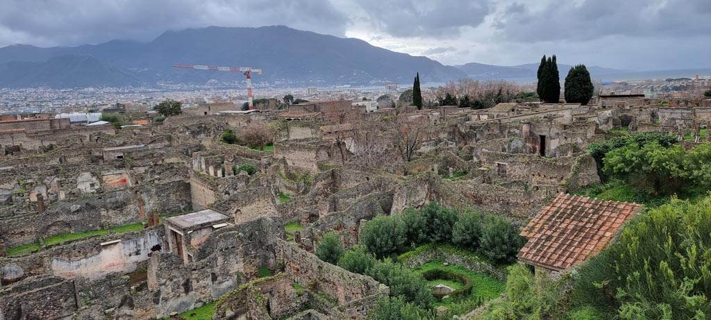 T11 Pompeii. Tower XI. January 2023.
Looking south-west from Tower XI towards Sorrentine peninsula, with garden pond of VI.7.23, lower centre right.
Photo courtesy of Miriam Colomer.