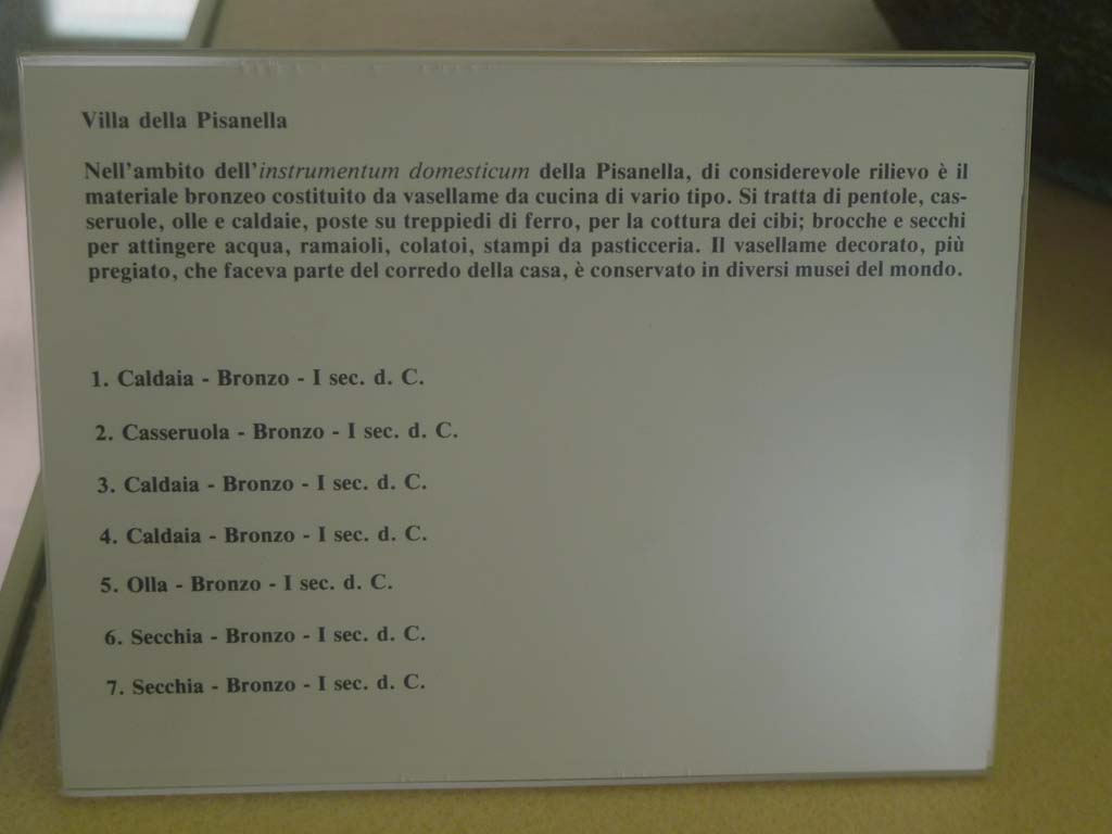 Villa della Pisanella, Boscoreale. July 2010. Information card on the 7 bronze kitchen pots in the photo above. Boscoreale Antiquarium.
Photo courtesy of Michael Binns.
