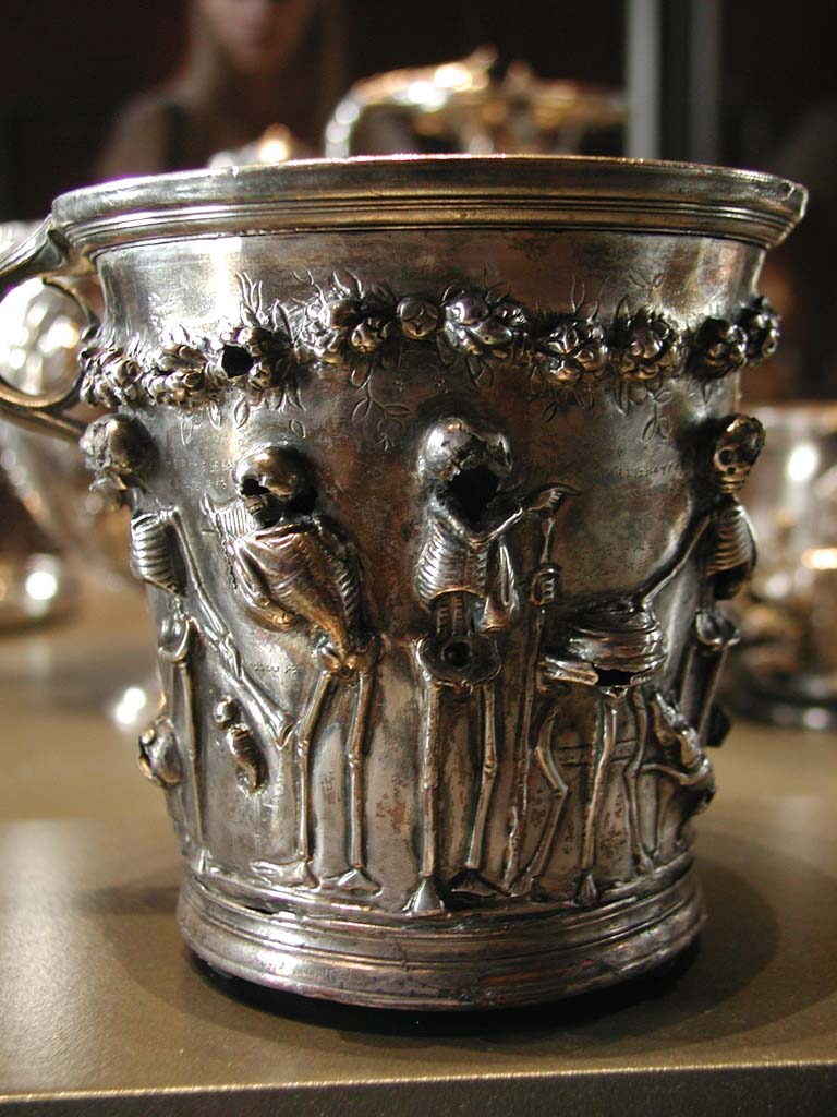 Villa della Pisanella, Boscoreale. Boscoreale silver. One of two skeleton cups. Under garlands of roses: four scenes. Dotted inscriptions giving meaning accompanied by epicurean maxims. Skeletons representing renowned authors: Euripides, Sophocles, Menander, Moschion, and philosophers: Zeno, Epicure, Monime of Athens, Demetrius of Phalerum accompanied by explicit sentences.
Une des deux gobelets aux squelettes. Sous des guirlandes de roses : quatre scènes. Inscriptions en pointillé donnant la signification accompagnés de maximes épicuriennes. Les squelettes représentant des auteurs de renom : Euridipe, Sophocle, Ménandre, Moschion, et des philosophes : Zénon, Epicure, Monime d'Athènes, Démétrois de Phalère accompagnés de sentences explicites.
Now in the Louvre, inventory numbers BJ1923 and BJ1924.