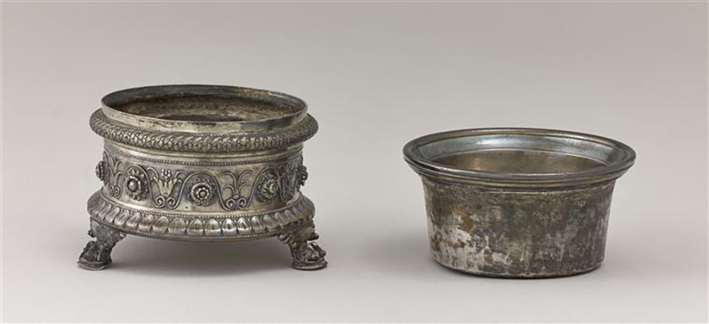 Villa della Pisanella, Boscoreale. Boscoreale Silver. Miniature tripod with zoomorphic foot supporting a salt cellar.
Guilloche decoration, tongues and friezes of palmettes and flowers. Owners name engraved in Latin: Pamphilus, imperial freedman.
Trépied miniature avec pied zoomorphe supportant une salière. Salière : décor de guillochis, languettes et frise de palmettes et de fleurs.
Nom propre gravé en latin : Pamphilus, affranchi impérial.
Now in the Louvre, inventory number BJ1999.
Photo © RMN-Grand Palais (musée du Louvre) / Stéphane Maréchalle.