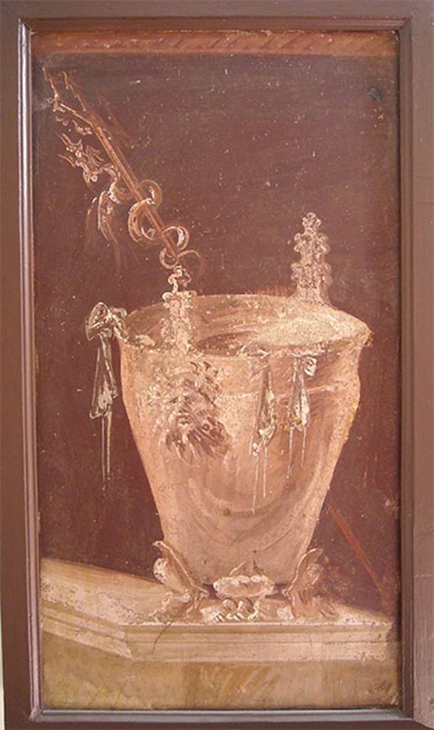 Villa of P. Fannius Synistor at Boscoreale. Peristyle E. Painting of a situla placed on a podium as an athletic winner’s reward. It has three low feet in the form of feline legs, with a tapered body with a high lip slightly turned. The handles are in the form of Silenus masks.
Outside the bowl hang the ribbons of the winner, while behind it, and placed obliquely a trident with twisted a fantastic animal. Now in Naples Archaeological Museum. Inventory number s.n. 7. See Sampaolo V. and Bragantini I., Eds, 2009. La Pittura Pompeiana. Electa: Verona. 56b, p. 176.