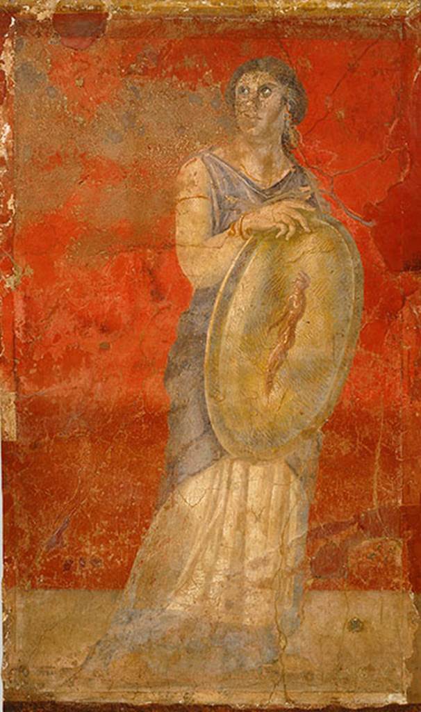 Villa of P Fannius Synistor at Boscoreale. Room H south end of east wall.
Standing woman clad in a white chiton and blue cloak, and holding a gold shield in her right hand. H
She is turning her head upwards to gaze towards the wall with Venus.
The front of the shield shows the image of a standing nude male figure who is adorned with a white headband, the same as those worn by Hellenistic dynasts.
This small male figure has been described as a reflected image on the shield, a popular motif in Hellenistic art.
However, since there is no image in the fresco cycle that corresponds to a reflection, the figure should be understood as an apparition, which, in antiquity, was viewed as prophetic.
The small apparition with a portrait like head in this particular fresco may refer to a Hellenistic royal heir, and the woman bearing the shield may represent a priestess or prophetess.
Photo © The Metropolitan Museum of Art, Rogers Fund 1903. Inventory number 03.14.7.
See www.metmuseum.org
See Barnabei F., 1901. La villa pompeiana di P. Fannio Sinistore. Roma: Accademia dei Lincei. p.57, Fig. 12.