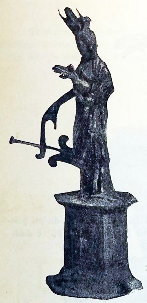 Scafati, Villa rustica detta di Domitius Auctus. 18th March 1899. Room “D”.
A silver statuette of Isis-Fortuna, 0.13m tall with the small hexagonal pedestal also of silver.
On her head, she has a modius (cylindrical headdress), a crescent moon and a lotus flower.
With the right hand, she held up a rudder and on the left wrist was a bucket and some corn.
It was finely worked and was important for the fusion of elements, more accentuated than what is seen in the figure of Isis-Fortuna in Pompeian paintings.
See Notizie degli Scavi di Antichità, 1899, p. 393, fig. 2.
