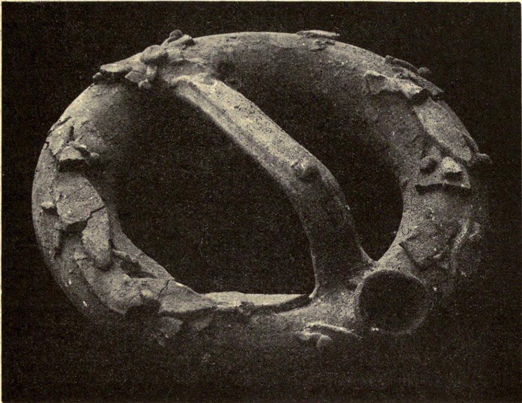 Boscoreale, La villa del Fondo Acunzo. 1903. Room 6, cubiculum.
Ring-shaped pot 0.26m wide, found in cubiculum.
This vessel is unique so far in the pompeian domestic instruments, for its shape and the technique of its ornamentation.
The outside consisted of a continuous tube with circular section, its outside diameter 0.045m.
The tube was decorated with lanceolate laurel leaves and round berries.
See Notizie degli Scavi di Antichità, 1921, p. 438-9, fig. 10.
