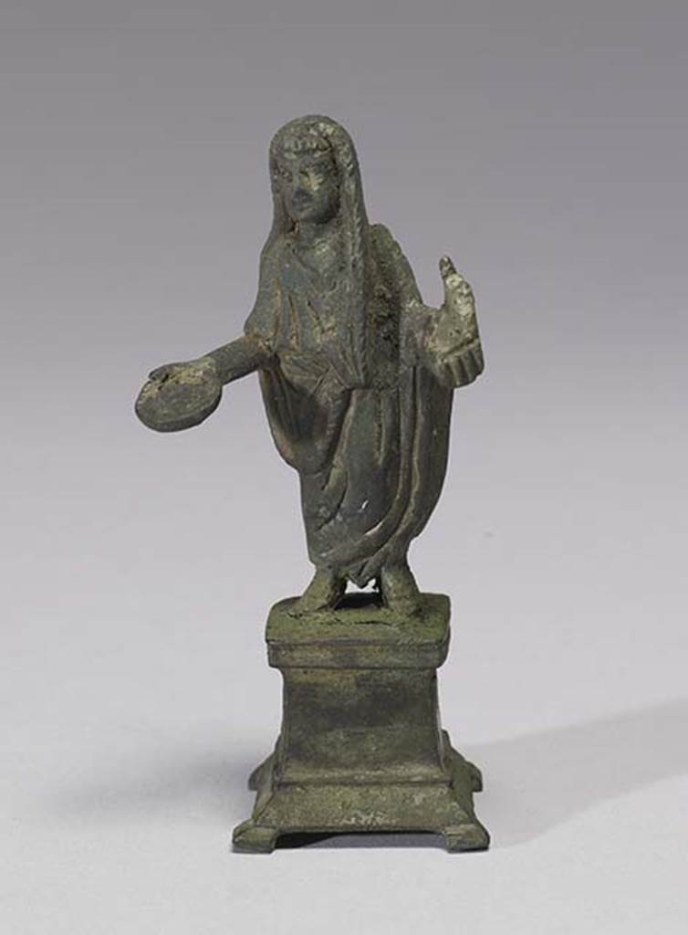 Boscoreale, Villa rustica in fondo D’Acunzo. Room 12, lararium.
Bronze statuette of sacrificing priest, 0.08m high, front view.
According to Della Corte, this represented a Genius familiaris, wearing the toga with a fold drawn up over his head.
He holds a patera in his right, and an acerra (small box) with incense in his left.
See Notizie degli Scavi di Antichità, 1921, p. 440.
Photo courtesy of The Walters Art Museum, Baltimore. Inventory number 54.752.
http://thewalters.org/
Creative Commons Attribution-ShareAlike 3.0 Unported Licence