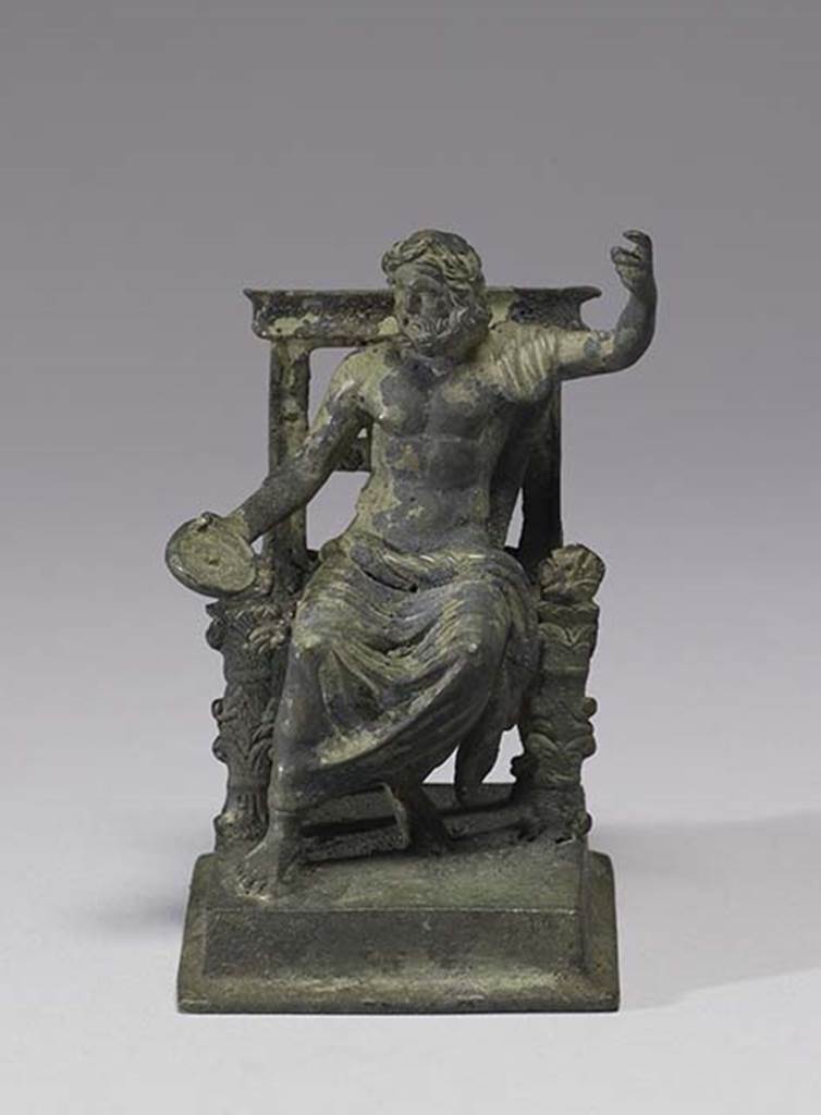 Boscoreale, Villa rustica in fondo D’Acunzo. Room 12, lararium.
Bronze statuette of seated Jupiter, front view.
According to Della Corte, the statue, (0.09 high including the square base) represented Jupiter.
He is bearded, nude, except for the cloak over his left shoulder and around his legs, and is seated upon a throne;
In his right hand he held a patera, the left is raised as if resting upon a high sceptre, now missing.
See Notizie degli Scavi di Antichità, 1921, p. 440.
Photo courtesy of The Walters Art Museum, Baltimore. Inventory number 54.750.
http://thewalters.org/
Creative Commons Attribution-ShareAlike 3.0 Unported Licence