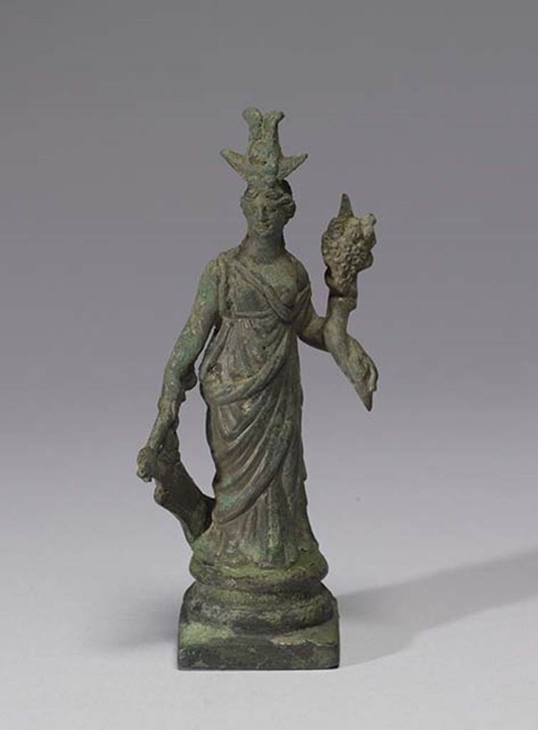 Boscoreale, Villa rustica in fondo D’Acunzo.Room 12, lararium.
Larger bronze statuette of Isis-Fortuna, 0.12m high including the base, front view.
She is fully clothed and has a crescent moon and a disk surmounted by two plumes upon her forehead.
In her right hand she holds a rudder, in her left hand a cornucopia.
Photo courtesy of The Walters Art Museum, Baltimore. Inventory number 54.751.
http://thewalters.org/
Creative Commons Attribution-ShareAlike 3.0 Unported Licence