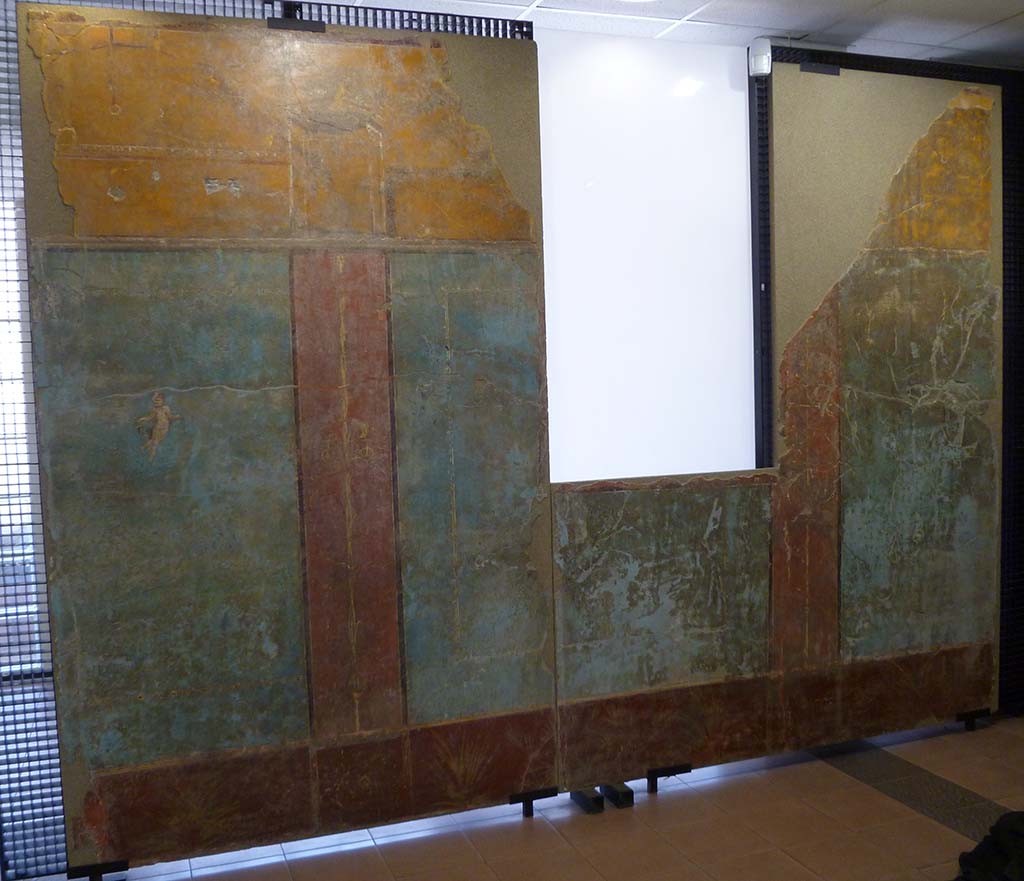 Boscoreale. Villa of Numerius Popidius Florus. Cubiculum 21. The entire west wall, cut in 2 pieces.
The east and west walls were adorned with gold candelabras with double twisted, metallic stems, or with simple, vegetal stems, with opposite leaflets.
Cupid with situla in right hand and thyrsus (?) in the left; the others were faded and vanished.
Le pareti est e ovest adorni di candelabri aurei a fusto doppio attorcigliato, metallico, o a caule semplice, vegetale, con foglioline opposte.
Erote con situla nella d. e tirso (?) nella sin.; gli altri erano svaniti.
Photo courtesy of Michael Binns. Now in Boscoreale Antiquarium.
See Garcia y Garcia L., 2017. Scavi Privati nel Territorio di Pompei. Roma: Arbor Sapientiae, p. 403, fig. 241.