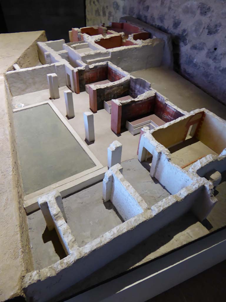 Complesso dei triclini in località Moregine a Pompei. September 2015. December 2000 model of excavated area.
At least five triclinia are clustered around a pillared portico.
Triclinium A, Triclinium B and Triclinium C are on the north side.
Triclinium D and Triclinium E are on the east side and are shown as undecorated.
The baths suite is in the north-west corner at the top of this photo.
The kitchen is in the north-east corner adjoining the two groups of triclinia.
Foto Annette Haug, ERC Grant 681269 DÉCOR.