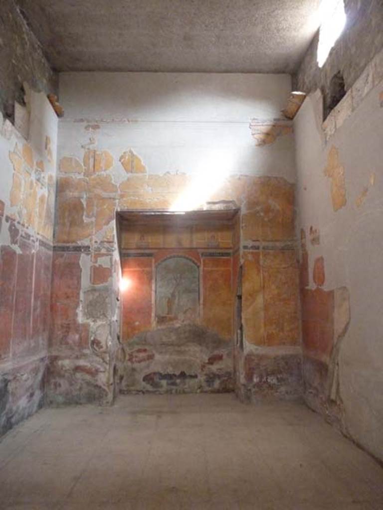 Oplontis Villa of Poppea, September 2015. Room 8, east wall with recess.
Secondo a Carlo Malandrino - (insieme agli ambienti 18 and 31 formava il complesso termale della casa).
Ha il pavimento con sospensurae e le pareti concamerate per il passaggio dell’aria calda proveniente dalla vicina cucina.
Le pareti sono dipinte in III stile. Nella nicchia di fondo, il quadro rappresenta Ercole nerl giardino delle Esperidi.
Al disopra del quadro e sul succielo del rincasso sono dipinte delle preziose miniature paesaggistiche e mitologiche.
See Malandrino, Carlo, 1978. “Oplontis”, (p.71-2, vedi 16,17 e 18)
(translation: Together with rooms 18 and 31 these formed the thermal (baths)complex of the House).
With suspended floor and walls recessed for the passage of warm air coming from the nearby kitchen.
The walls are painted in III style. In the rear niche Hercules is represented in the garden of the Hesperides.
Above the picture and on the ceiling recess, precious miniatures of landscapes and mythological subjects are painted..
See Malandrino, Carlo, 1978. “Oplontis” (p.71-2, see rooms 16, 17 and 18 on his plan)