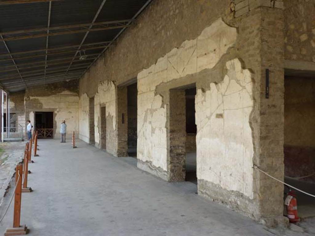 Oplontis, September 2011. Portico 60, looking south along portico on west side of swimming pool. At the far end is the doorway to room 66, then in the west wall are the doorways to rooms 46, 63, 65, and on the right, two doors of room 75. Photo courtesy of Michael Binns.