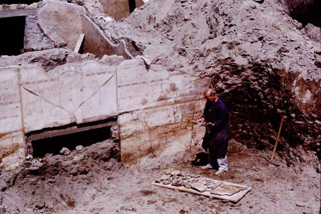 Oplontis, 1975. Restorer collecting the fallen pieces of plaster from Area 60, the portico overlooking the pool. The doorway would lead into room 72, and the painted wall would be on its north side. Photo by Stanley A. Jashemski.
Source: The Wilhelmina and Stanley A. Jashemski archive in the University of Maryland Library, Special Collections (See collection page) and made available under the Creative Commons Attribution-Non Commercial License v.4. See Licence and use details. J75f0090