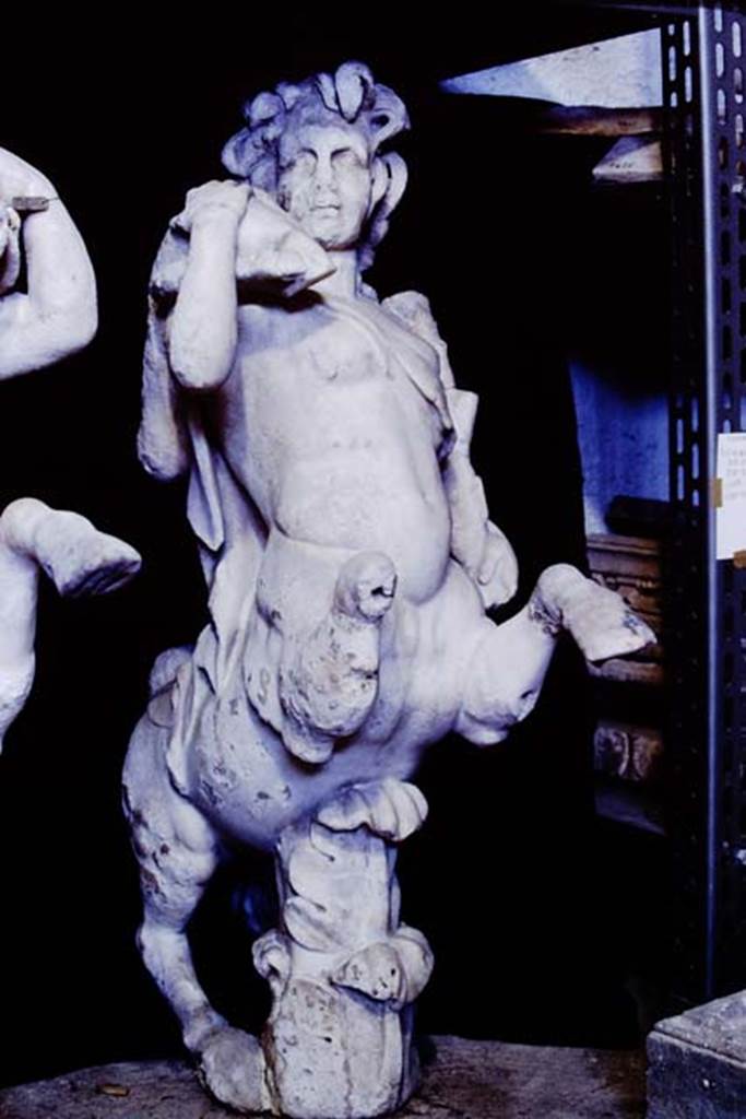 Oplontis Villa of Poppea, 1977. One of a group of four centaurs, a female holding a club and a fawn on her shoulder.
Two centaur fountains had been on each side of the passageway.
There was no evidence of pipes, so they had not been used as fountains in their final location.
Photo by Stanley A. Jashemski.
SAP{ inventory number 70071.
Source: The Wilhelmina and Stanley A. Jashemski archive in the University of Maryland Library, Special Collections (See collection page) and made available under the Creative Commons Attribution-Non Commercial License v.4. See Licence and use details.
J77f0339
According to De Caro, a group of four centaurs were found under portico 33 on 17th February 1970.
When they were found, they were very badly damaged. Heads and limbs were mostly detached and it was necessary to provide patient and pain-staking work of re-composition.
See De Caro, S.1976. Sculture dalla villa “di Poppea” in Oplontis (p.198) in Cronache Pompeiane, II, 1976, (p.184-225)