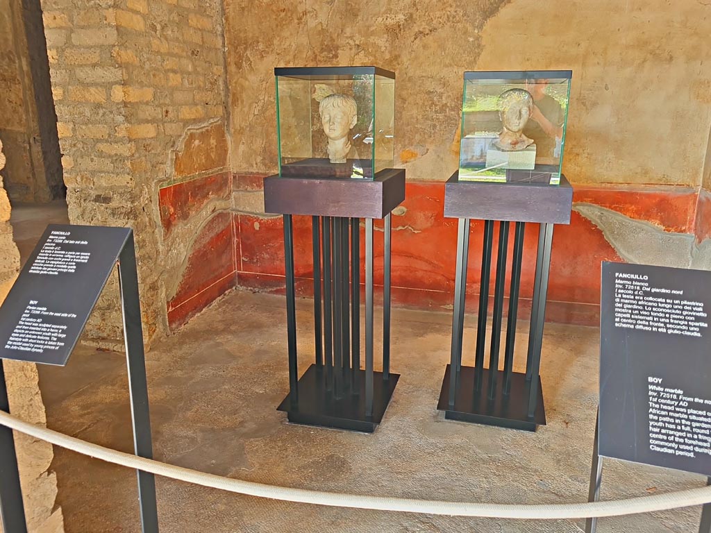 Oplontis Villa of Poppea, October 2023.
Room 88, looking west through doorway from Portico 60, towards two marble heads of boys on display here.
The one on the left (inv. 73299) was found on the east side of the pool and the one on the right (inv. 72518) along one of the paths in the north garden.
Photo courtesy of Giuseppe Ciaramella.