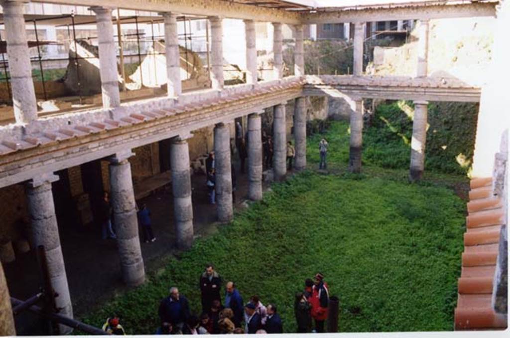 Oplontis, Villa L. Crassius Tertius. March 2005. Looking south-west across courtyard 27 from the upper level.
According to the Soprintendenza, il nucleo centrale dell'edificio è costituito da un porticato a due ordini di colonne doriche in tufo grigio di Nocera.
The core of the building consists of a portico with two rows of Doric columns in grey Tuff from Nocera. 
See Villa on the Soprintendenza web site
