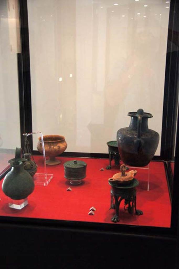 Gragnano, Villa rustica in Località Carmiano, Villa A. Items found in various rooms.
Stabiae Antiquarium, inventory numbers
63539 bronze wine jug with trefoil mouth, found in room 6.
63437 bronze hanging perfume holder, found in room 1.
63464 terracotta cup on a tall trumpet foot, found in room 7.
63528 circular bronze pyx with hinged lid, found in room 9.
63278 63279 bronze lamp stands, found in room 2.
63543 terracotta hanging lamp with nozzles at each end, found in room 6.
63377 bronze jug with ribbon rim, found in room 4.
Photo courtesy of Margaret Hicks.
See Guzzo, P, Bonifacio, G, and Sodo, A.M., curated by (2007) Otium Ludens. Castellammare di Stabia: Nicola Longobardi, pp. 164-6.
See Bonifacio G., 2004. In Stabiano: Exploring the Ancient Seaside Villas of the Roman Elite. Castellamare: Nicola Longobardi, p. 137.