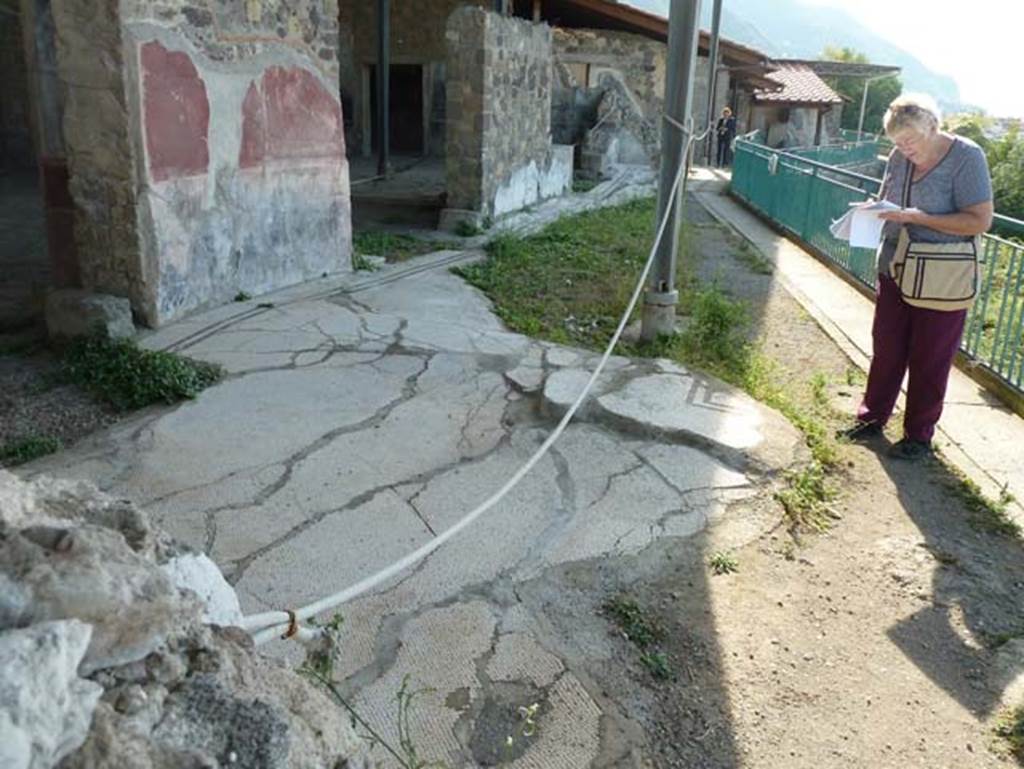 Stabiae, Secondo Complesso, September 2015. Room 12, looking west across remaining mosaic flooring.
In the centre of the mosaic floor was an emblema, but only a small part of the east corner remains now, formed by two black bands on the white mosaic flooring.