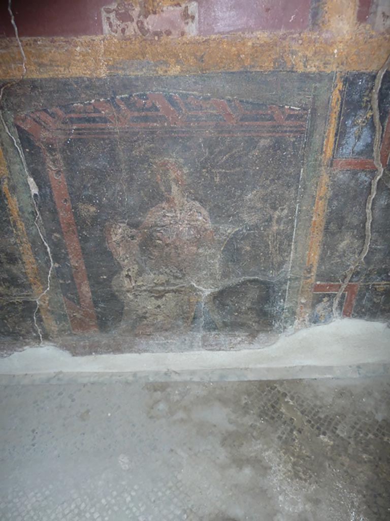 Stabiae, Villa Arianna, September 2015.
Room 5, painted seated figure on panel in black zoccolo from east wall.