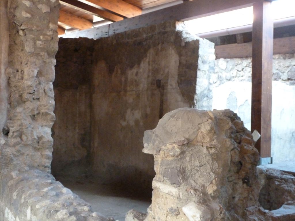 Stabiae, Villa Arianna, September 2015. Room 28, looking towards north-east corner of room and east wall.
According to the description board, on the northern wall there was a part of the lead water-duct (fistula) to the pool lying behind it.