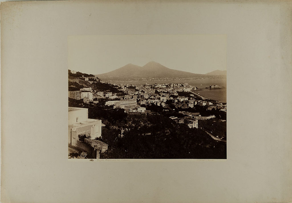 Vesuvius, 1860-1890. View of Naples from the Vomero district, with Vesuvius in the distance.
Photo title at bottom is “No. 1165. Napoli. Panorama dal Vomero Sommer – Napoli”.
Museum für Kunst und Gewerbe Hamburg, inventory number P1981.370 (Public Domain).
See https://sammlungonline.mkg-hamburg.de/de/object/No.-1165.-Napoli.-Panorama-dal-Vomero/P1981.370/mkg-e00135889